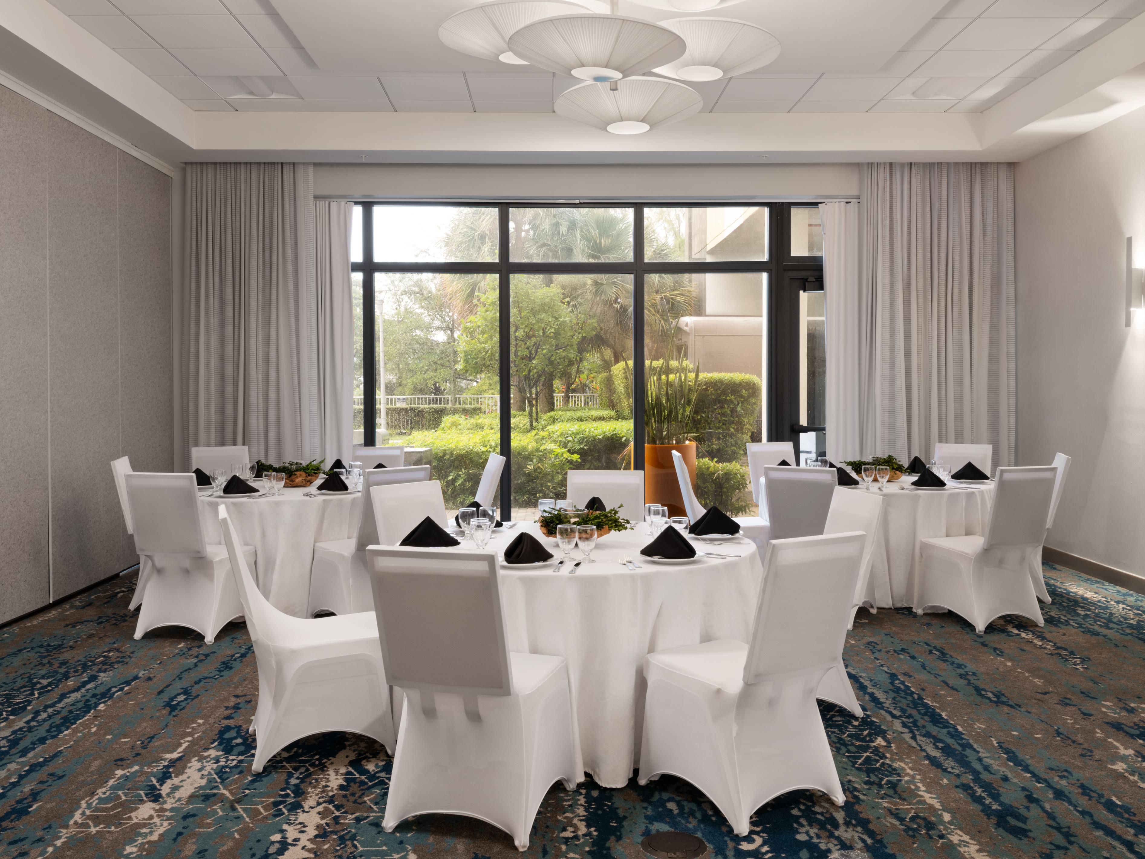 Event space with round tables set up with cutlery, plates and decor