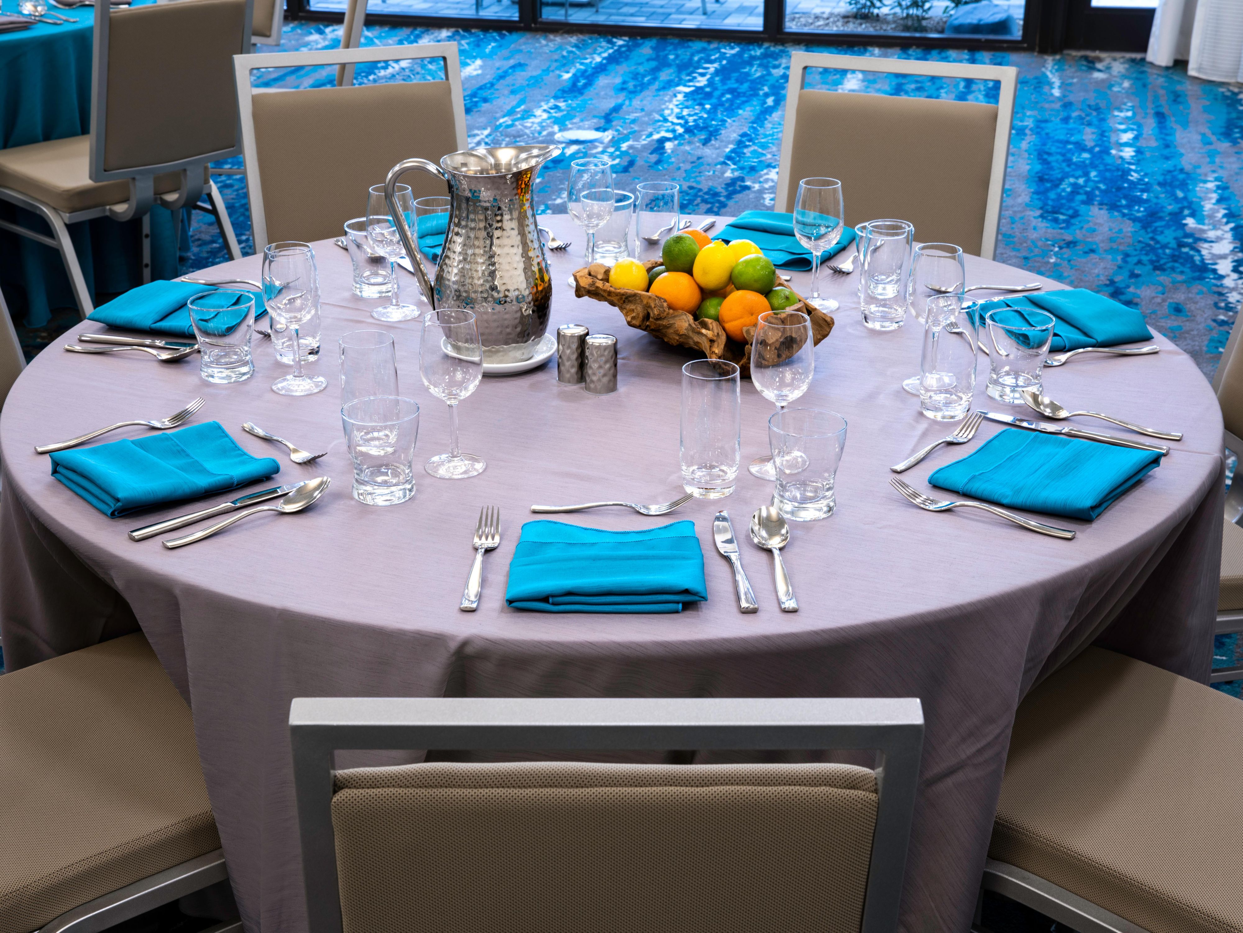 Event space with round tables set up with cutlery, plates and decor