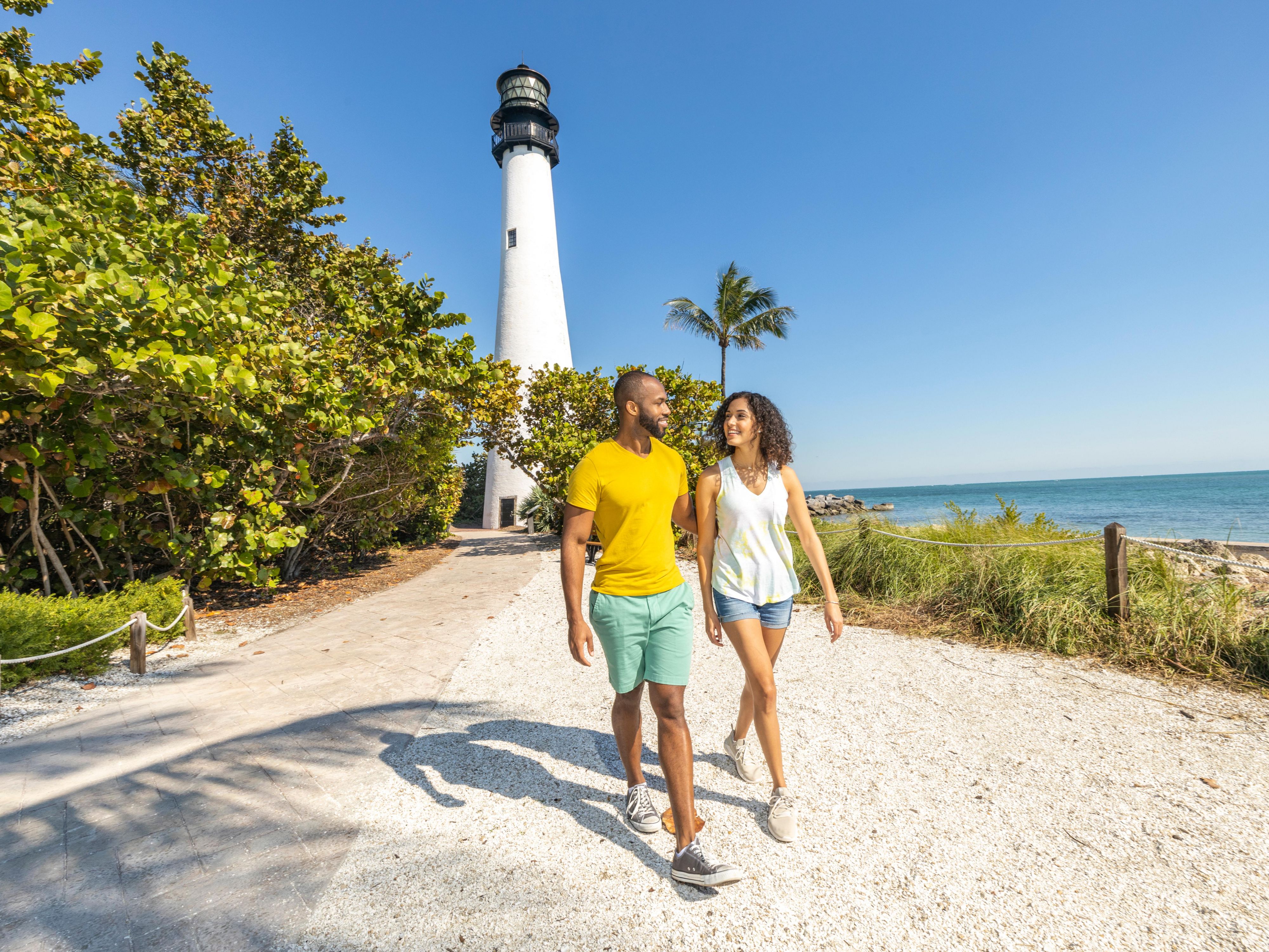 Couple walking with light house in background