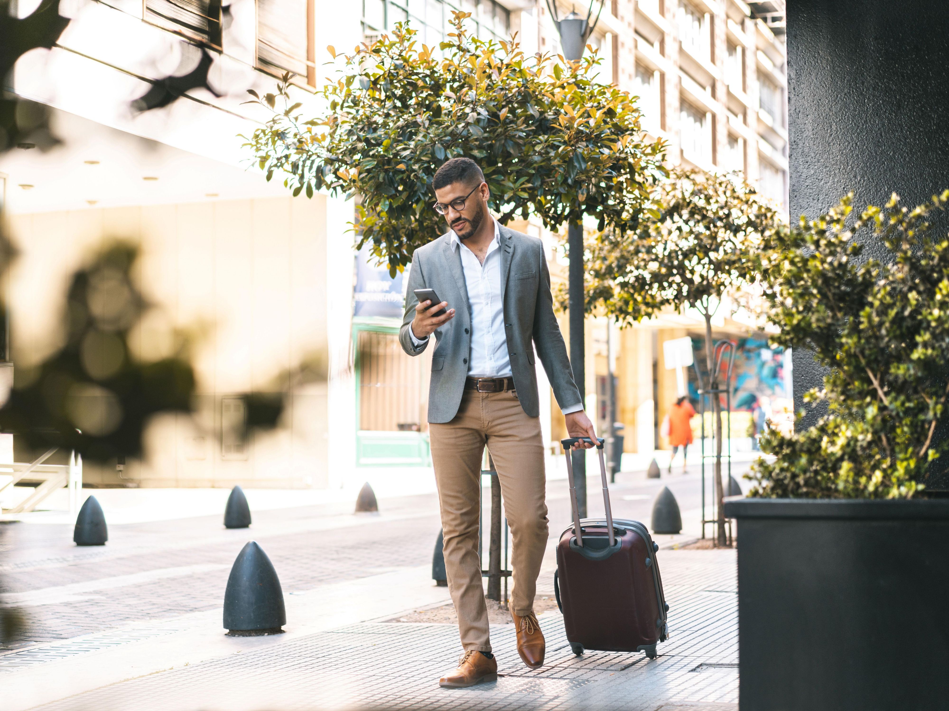 Businessman with a suitcase and a smartphone