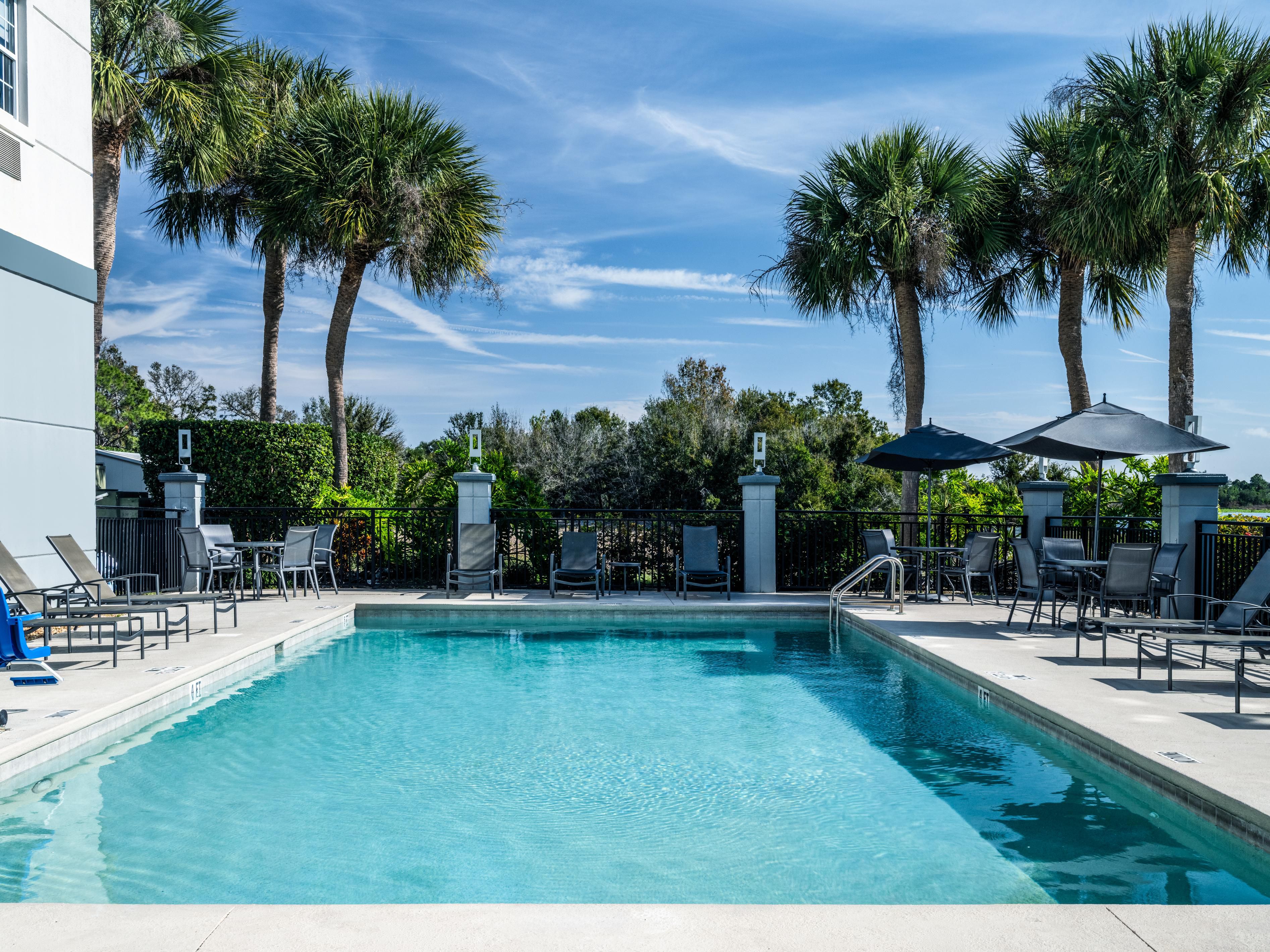 Sparkling outdoor pool surrounded by palm trees