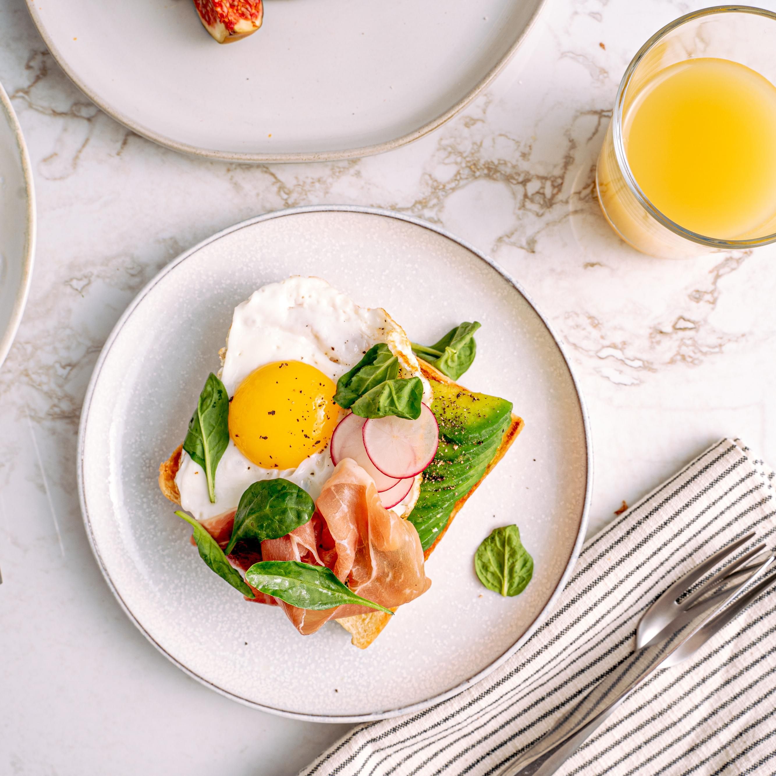 Avocado toast with an egg and prosciutto 