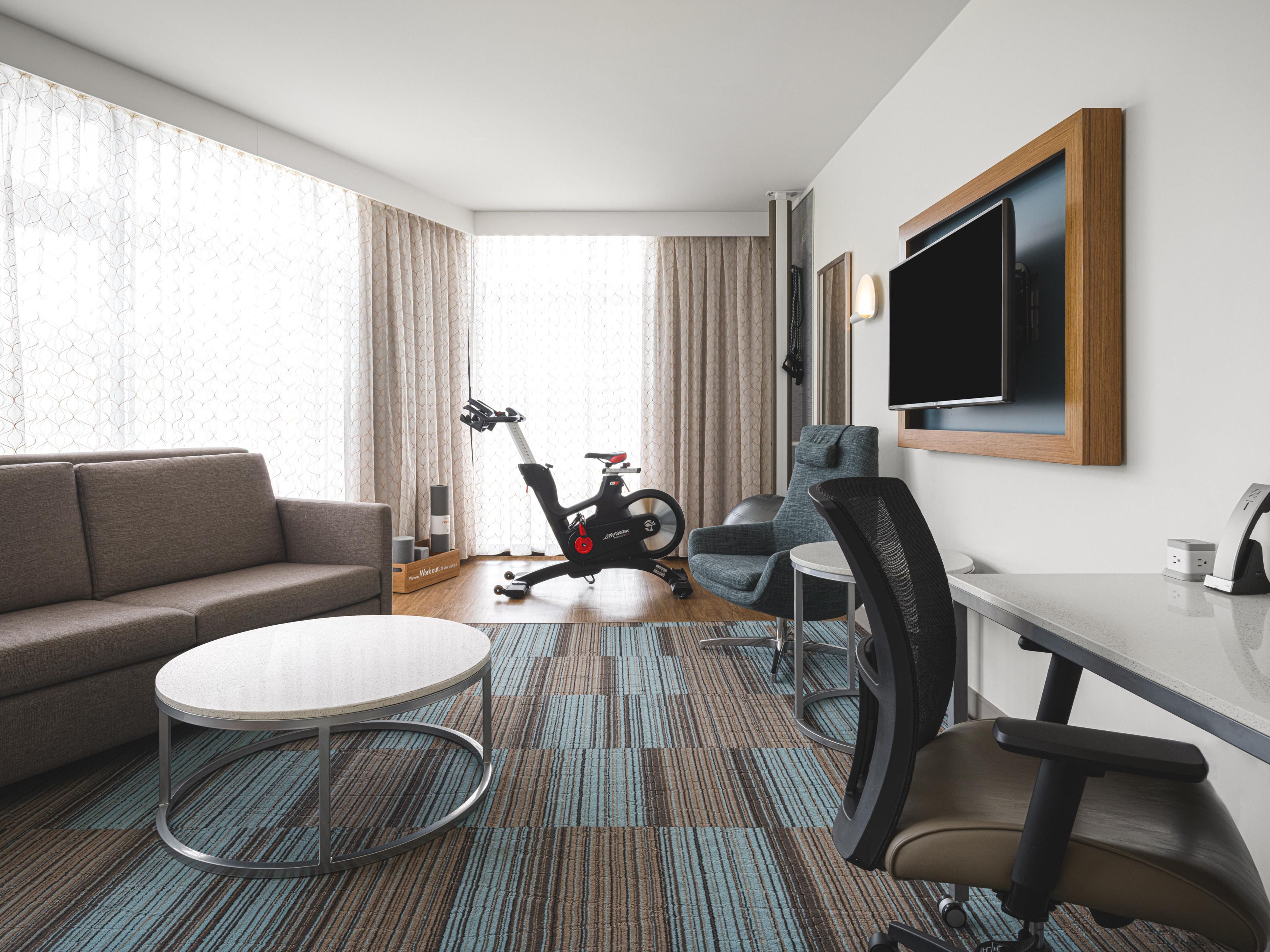 Guest room with work desk, chair and exercise bike 