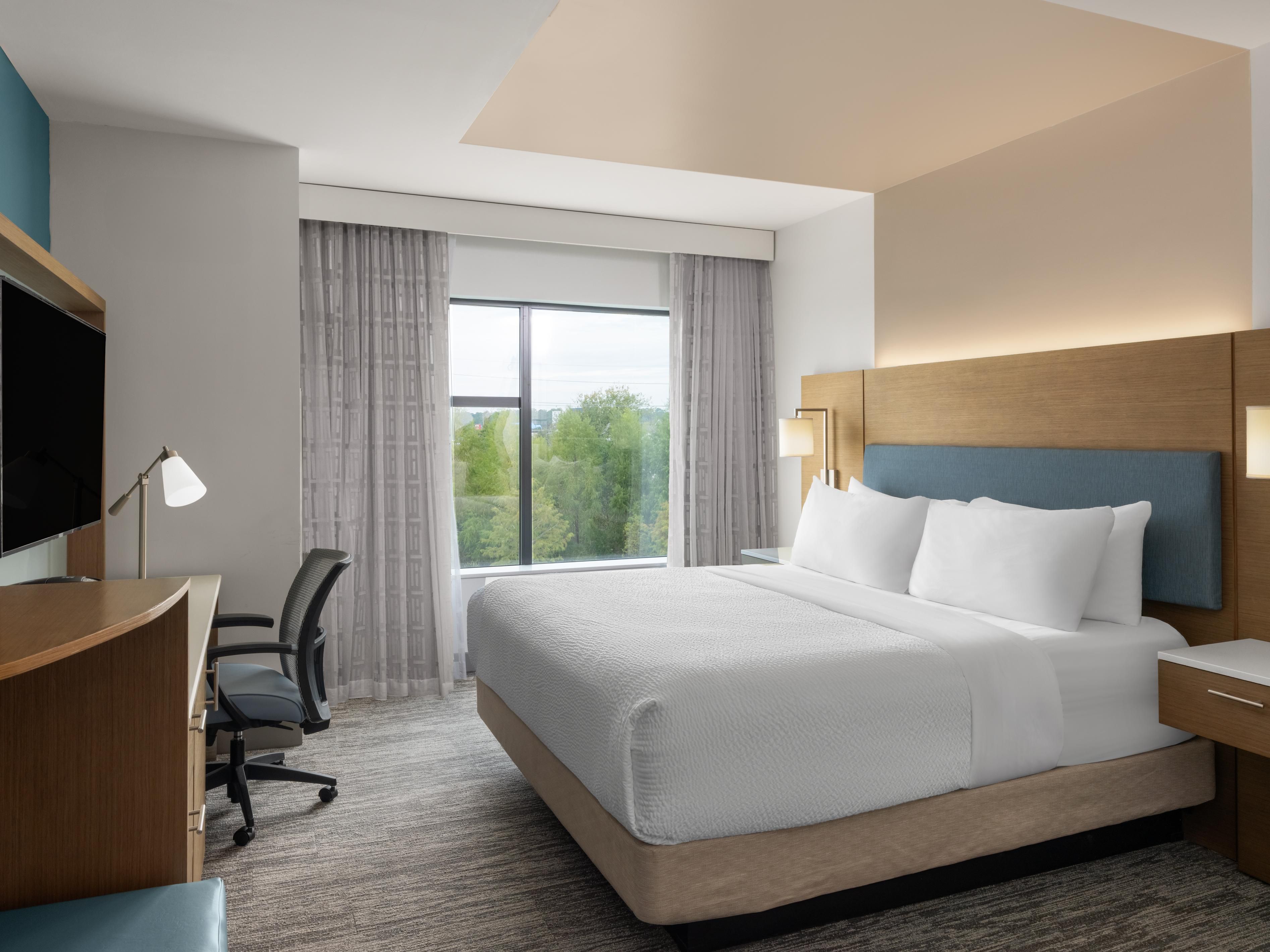 Spacious king room with modern workspace and relaxing design.