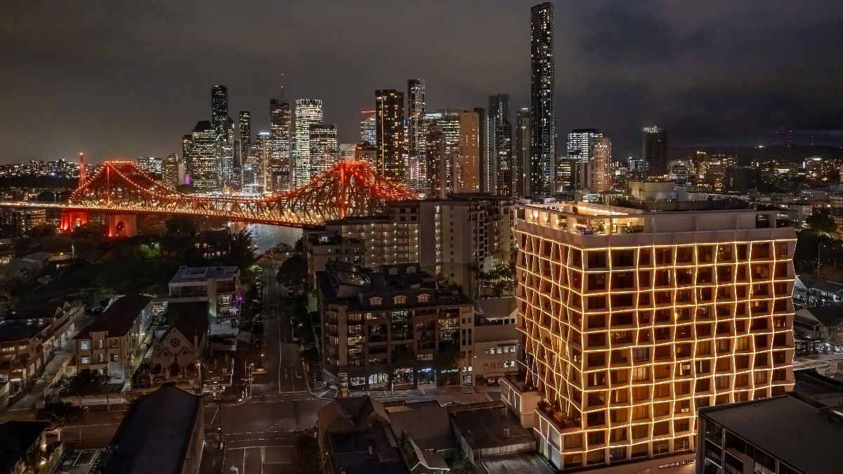 Illuminated city skyline with glowing red bridge at night