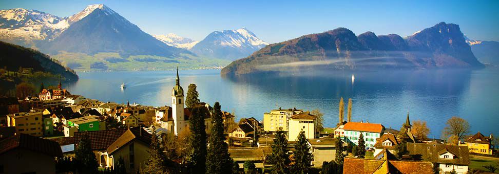 Mountainside view village by Lake Lucerne with Swiss Alps in background