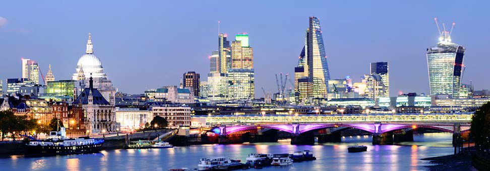 London Skyline at night with the Thames River in foreground