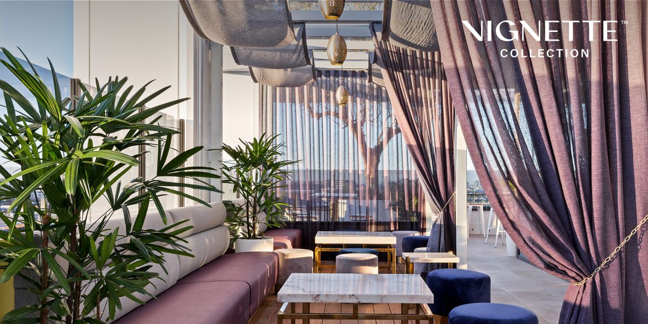 Beautiful seating area with purple drapes and cushions and accents of blue