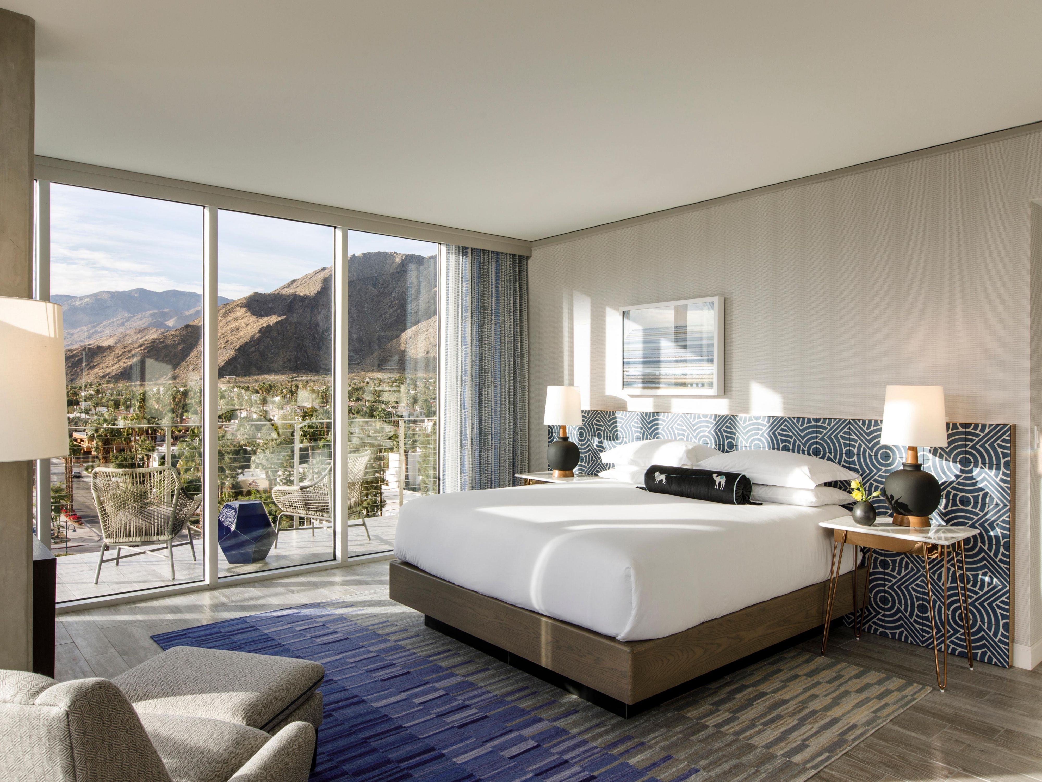 Elegant hotel room with floor to ceiling windows looking out at a mountain range