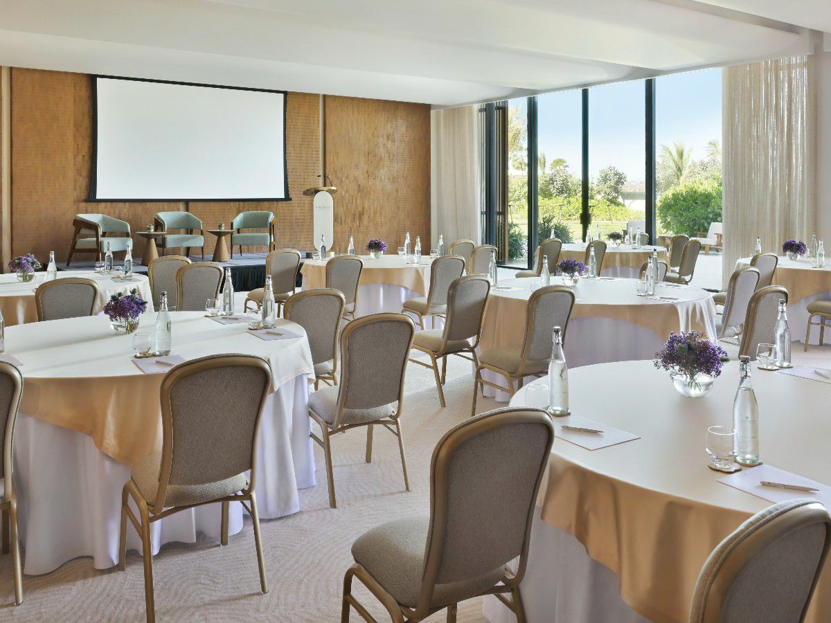 Elegant banquet hall with tables and presentation screen.