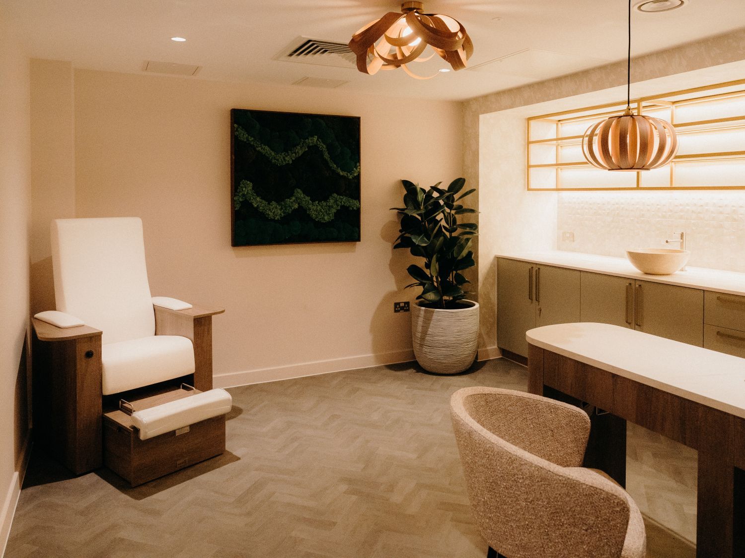 spa treatment room feauting a plush chair, a table, and featured lighting