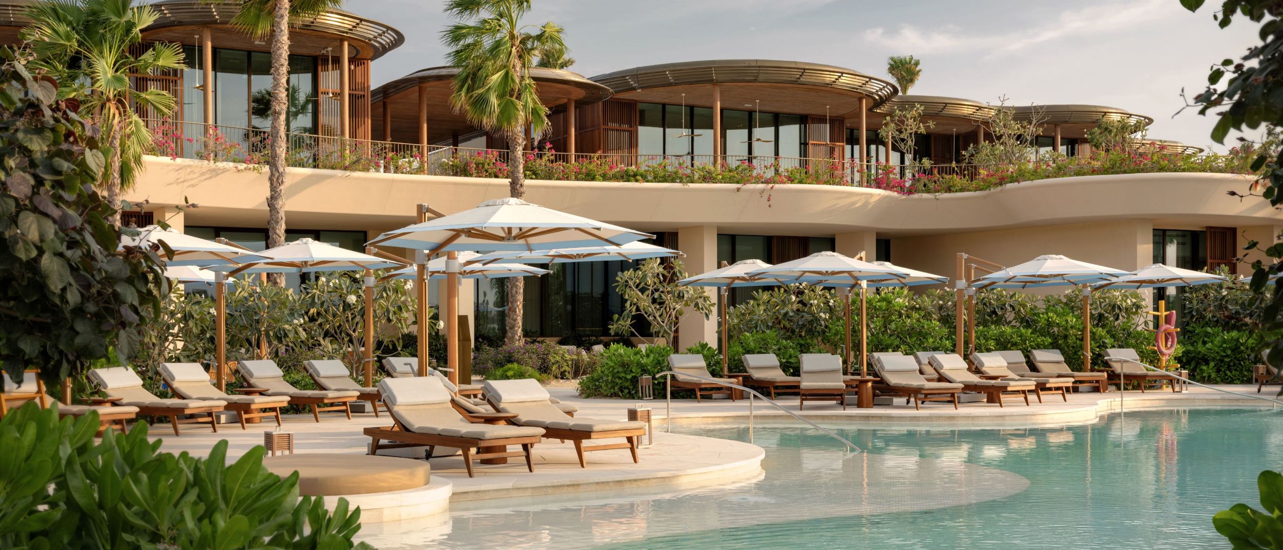Swimming pool with loungers at golden hour.