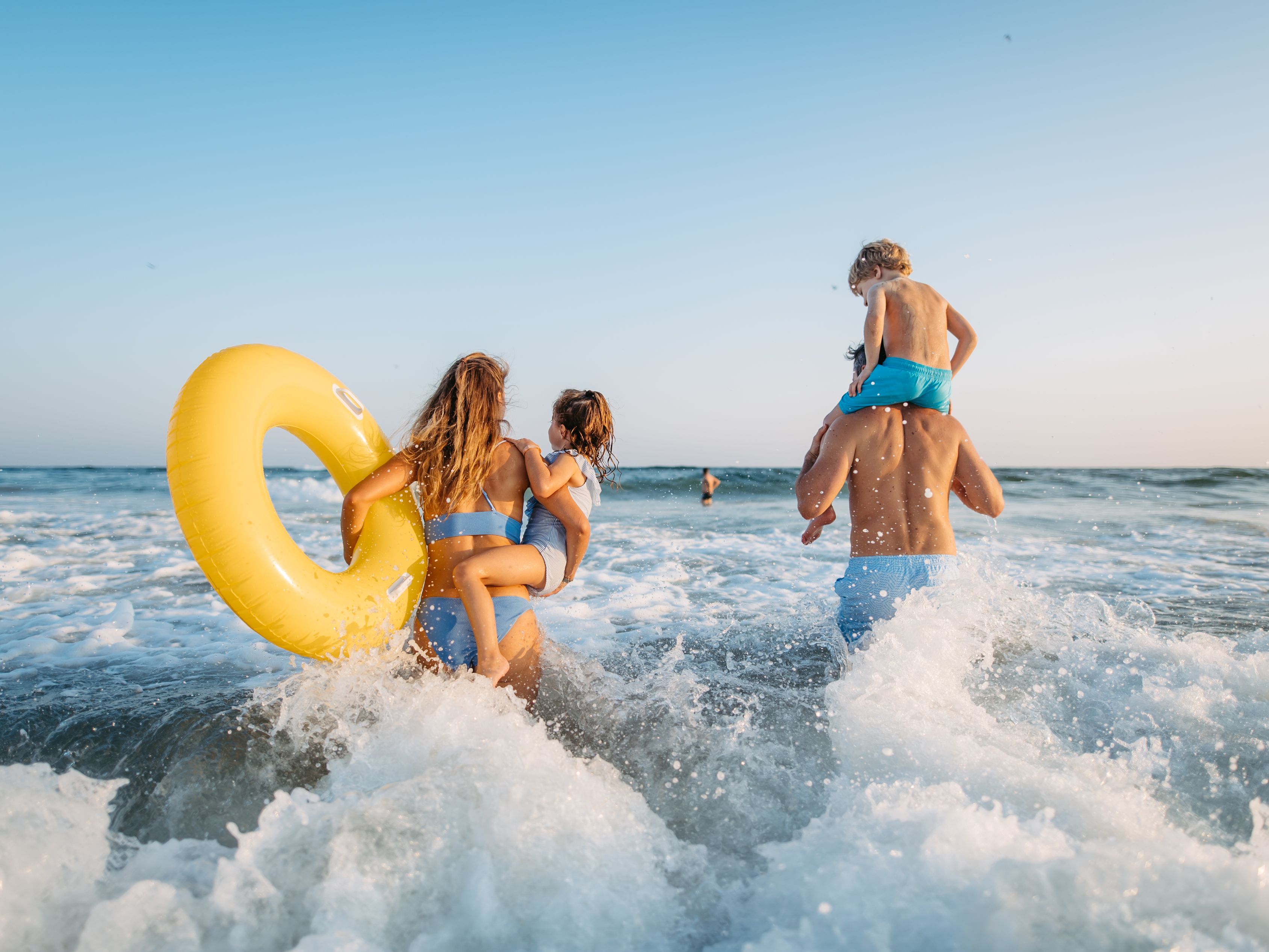 Family in the ocean at the beach.