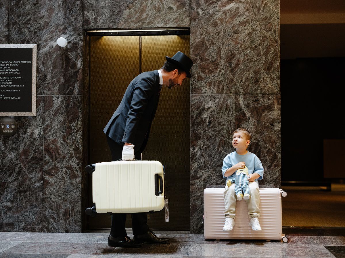Porter welcoming a child with luggage for a family hotel stay at InterContinental Brisbane.