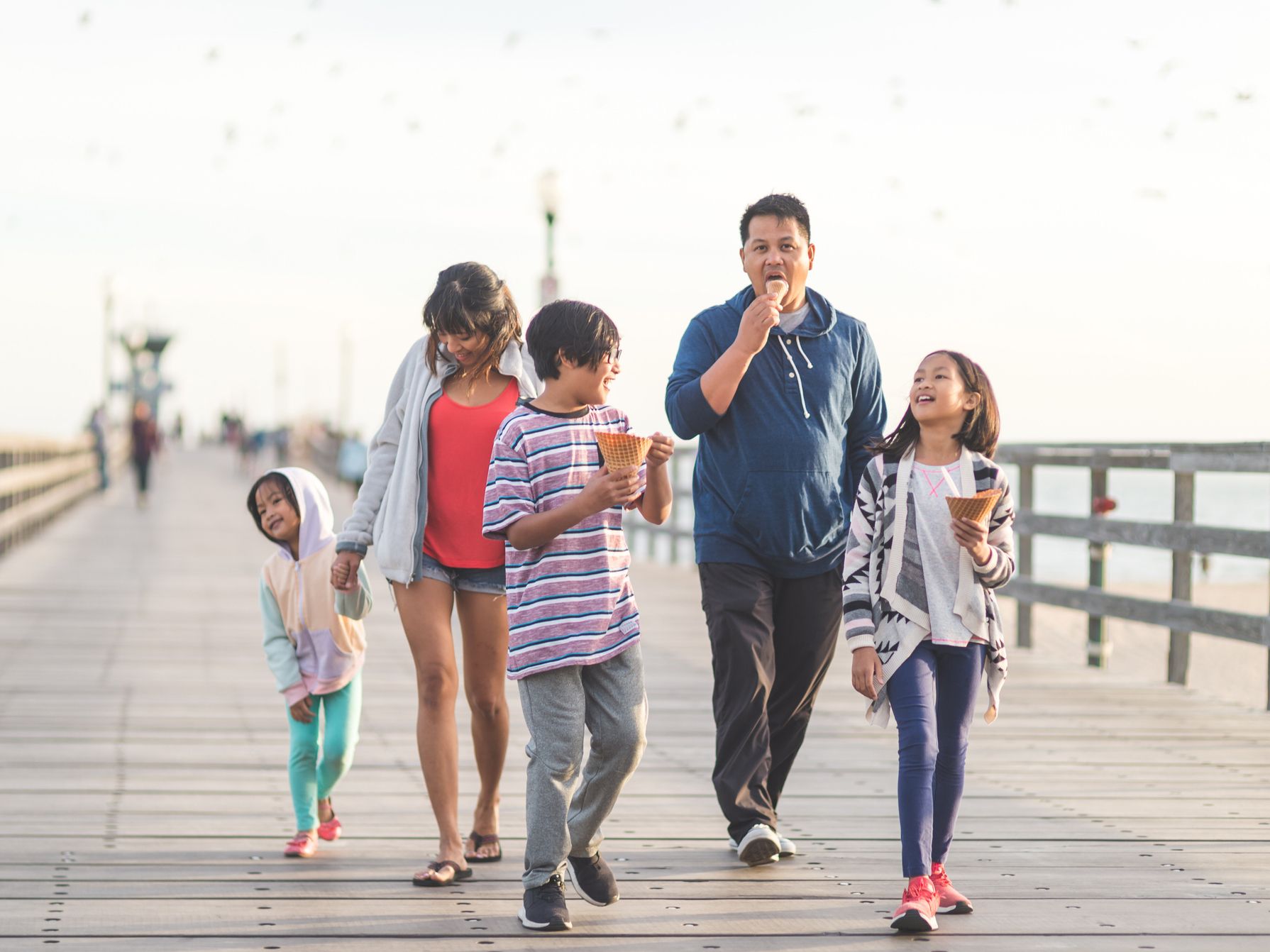 Family walking on boardwalk eating ice cream