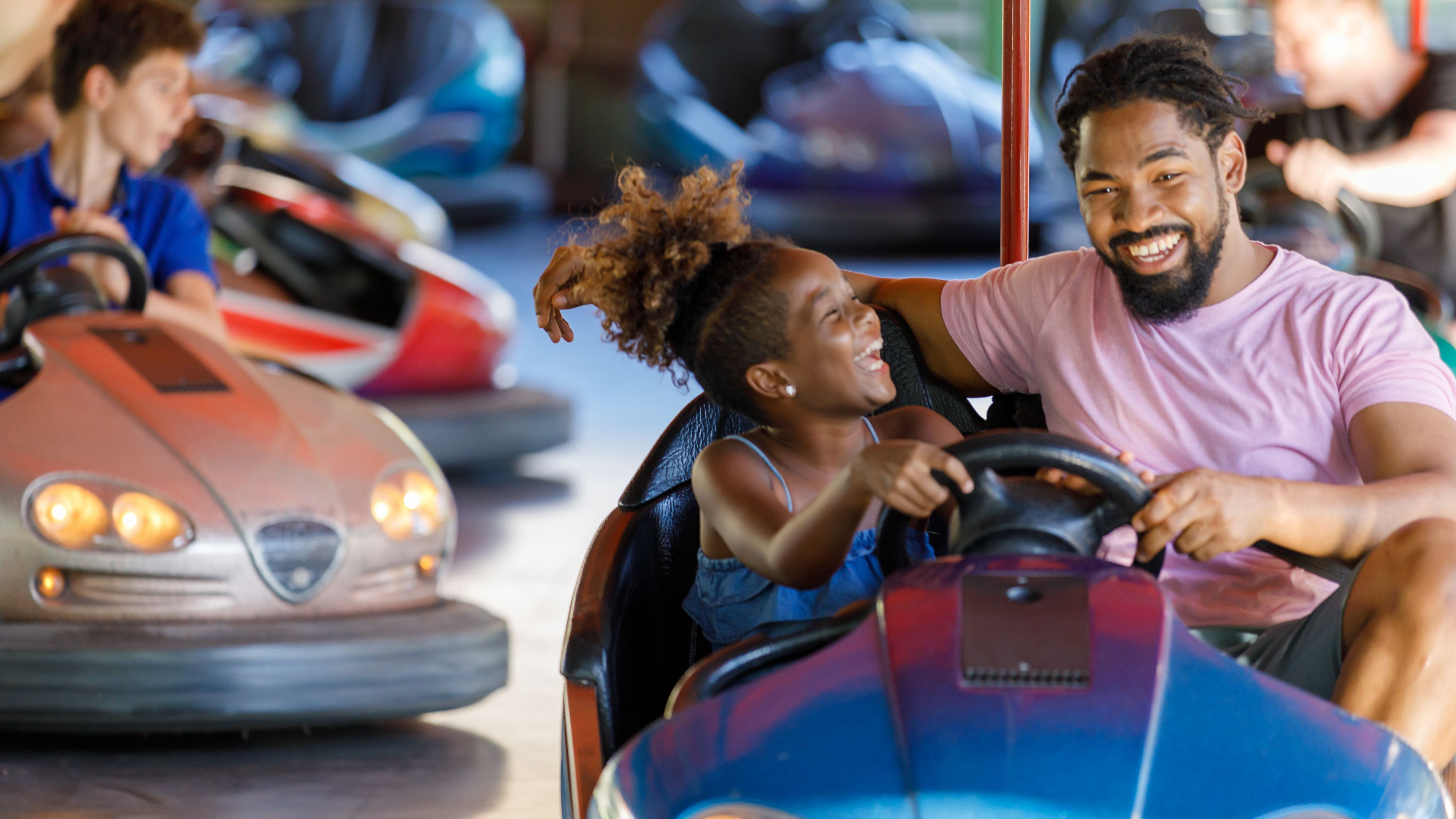 Father and daugher riding bumper cars