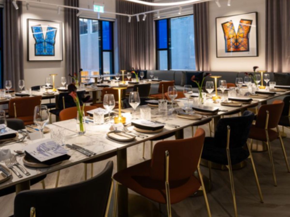 Elegant restaurant dining room with set tables and artwork.
