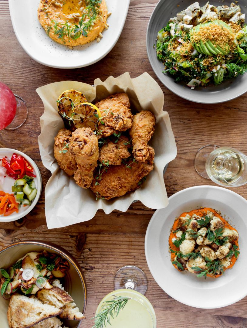 table with family meal style service chicken, salad, appetizers and more