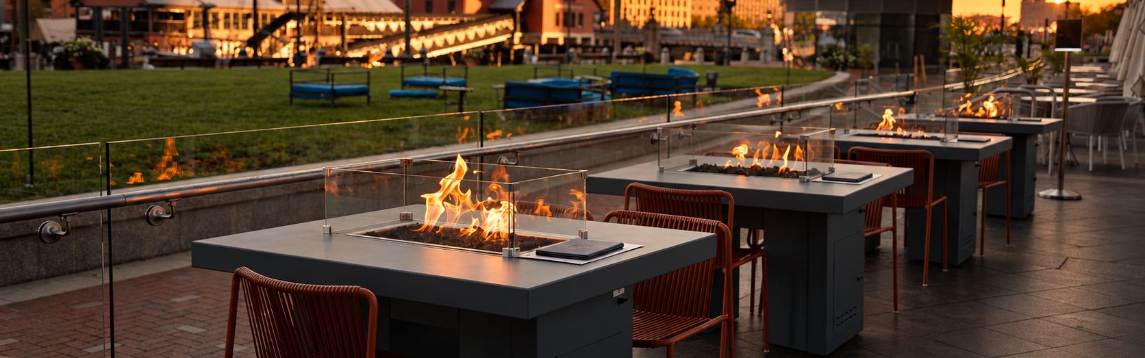 Outdoor terrace with fire tables overlooking Boston Harbor at sunset