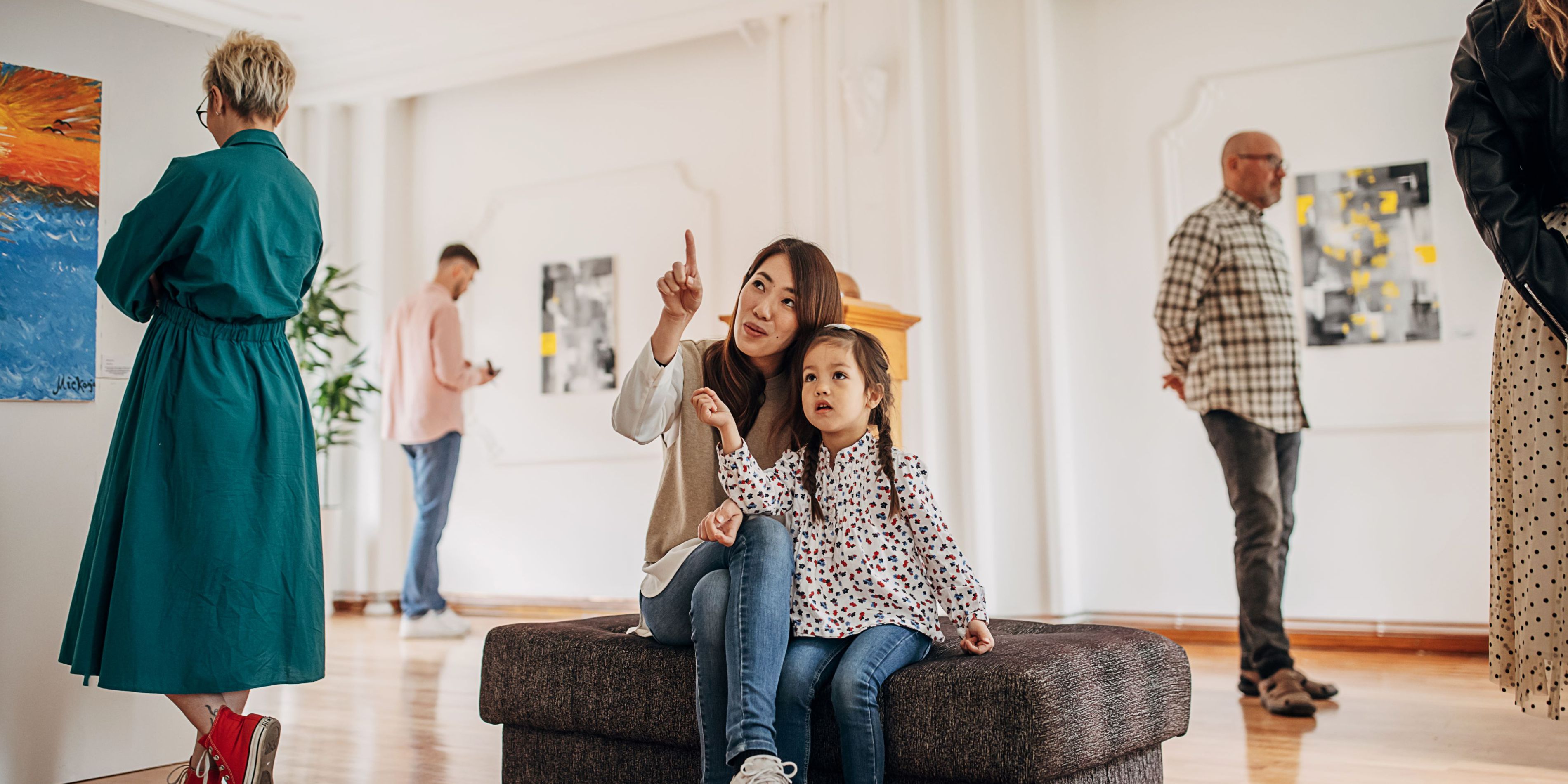 Mom and daughter looking at art in a museum