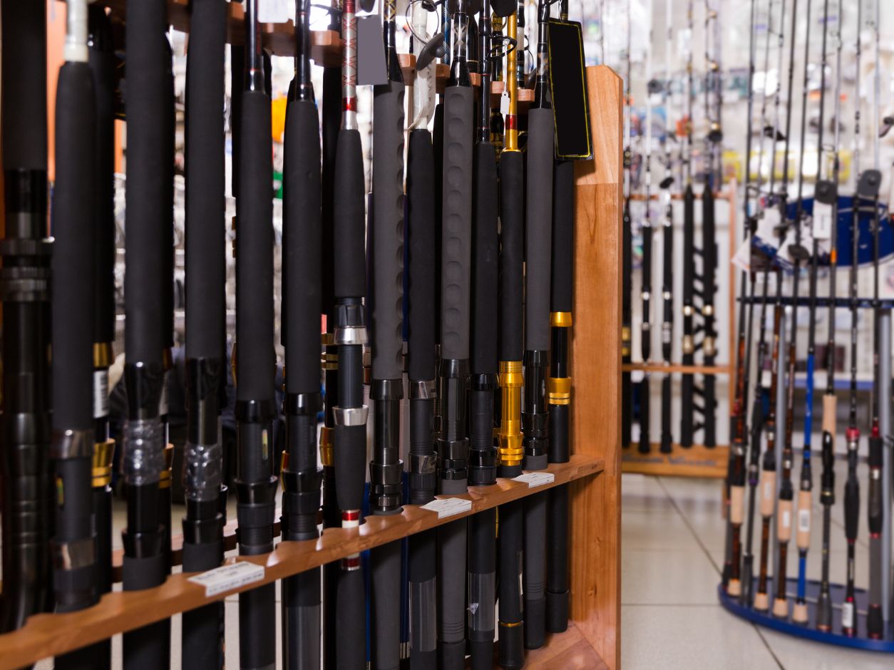 Fishing poles lined up in a row on a shelf