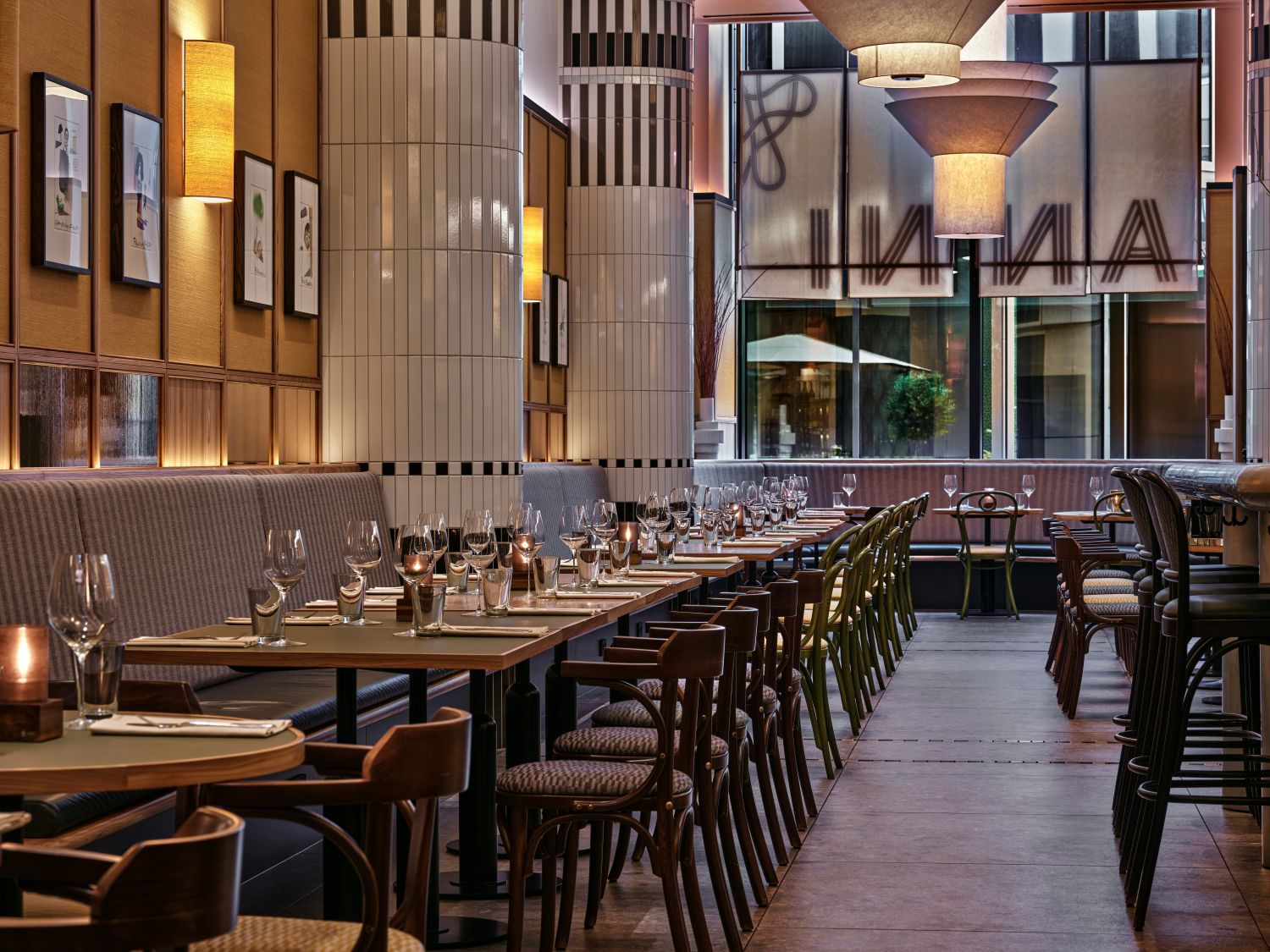 ANNI dining seating area with booths and empty wine glasses on tables