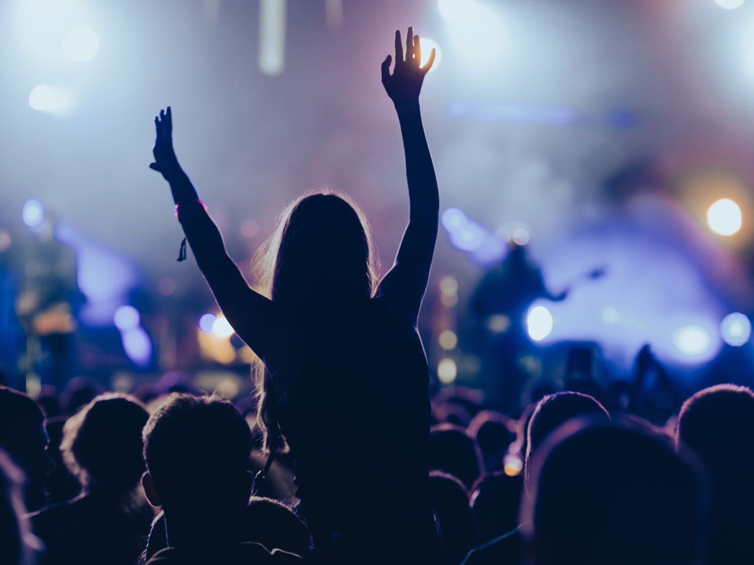 concert inside venue with blue lights and a shadow of a person