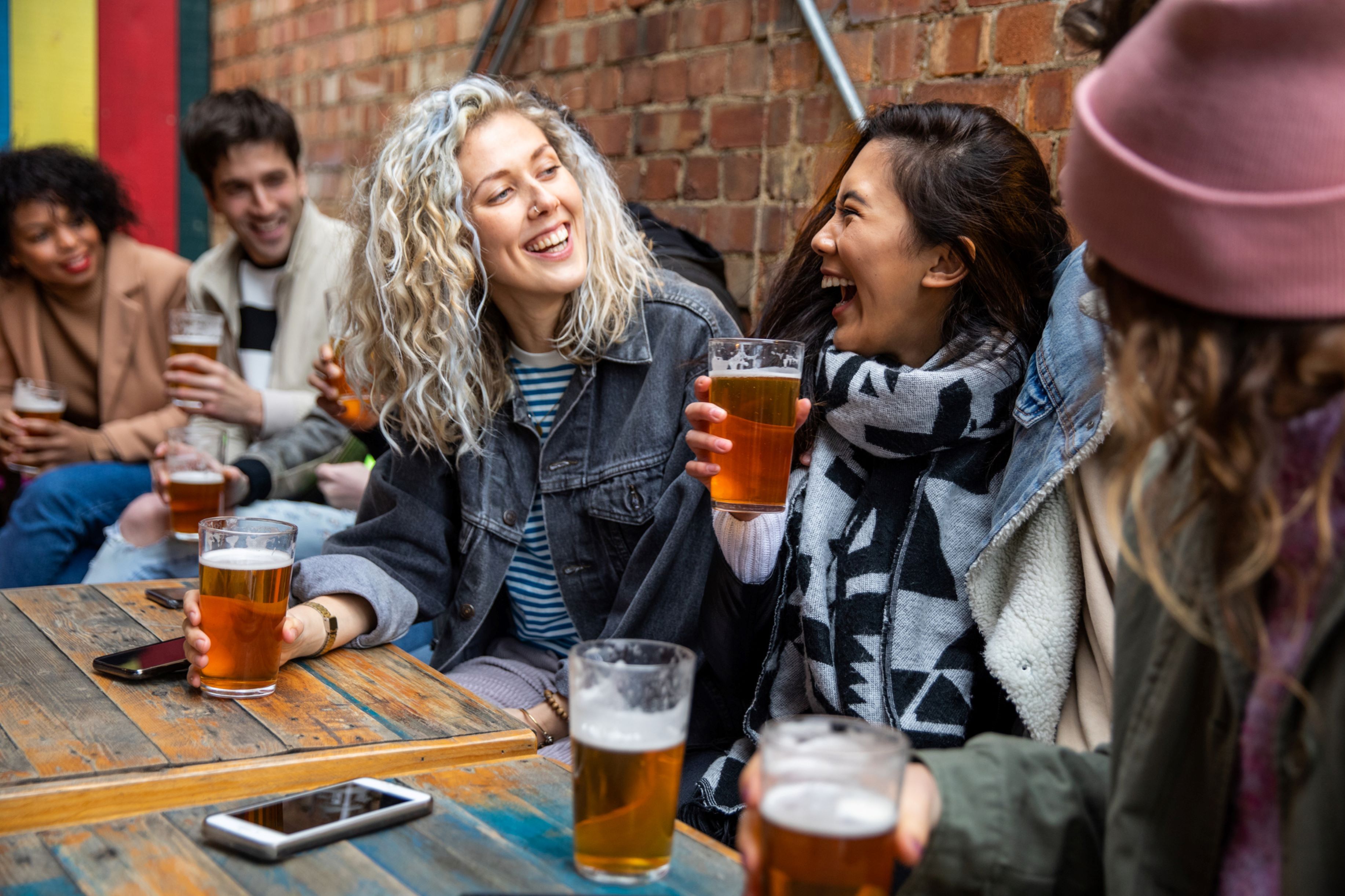 Friends sitting and laughing together at a brewery.