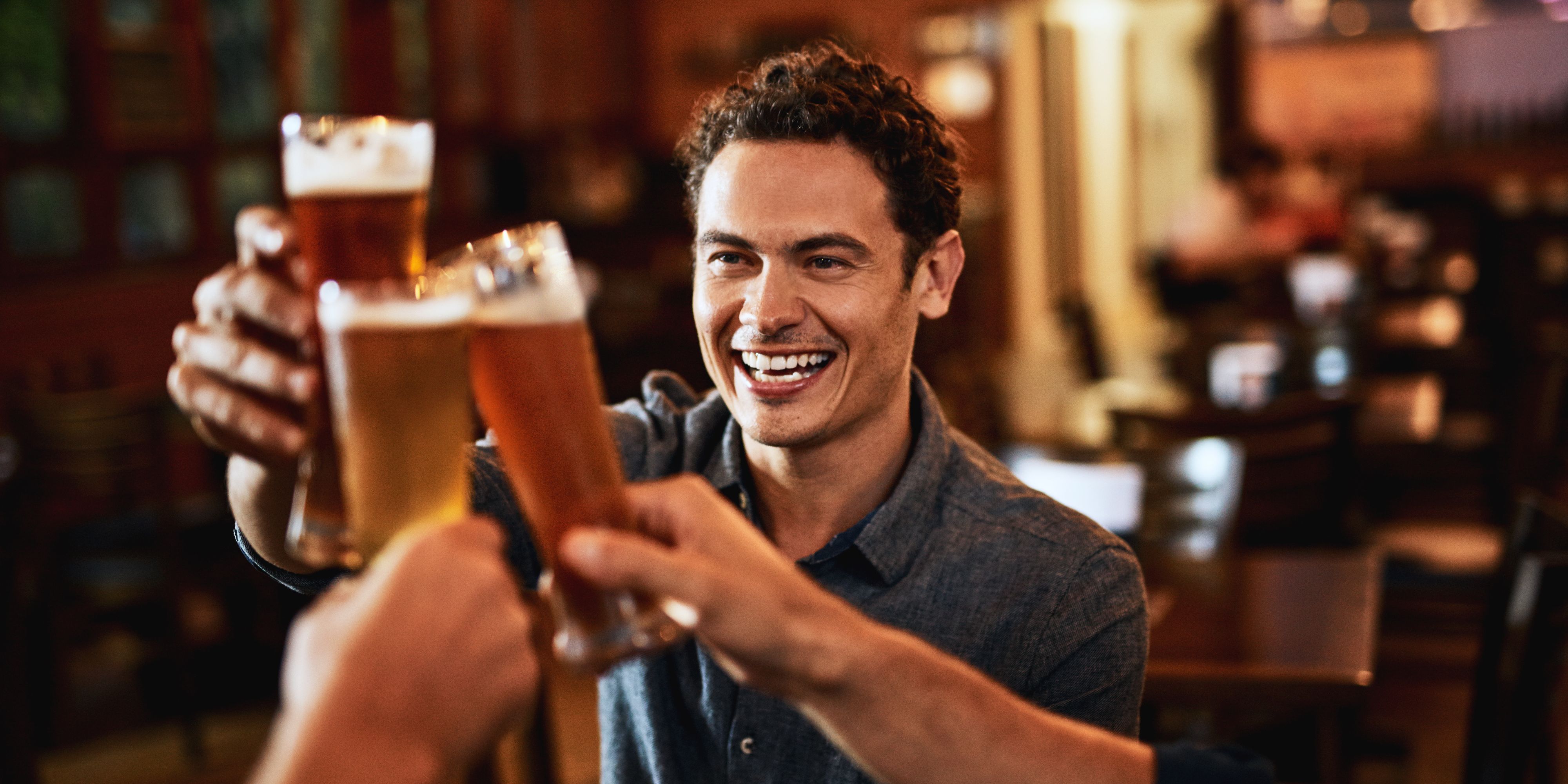 Man toasting with his beer with his friends.