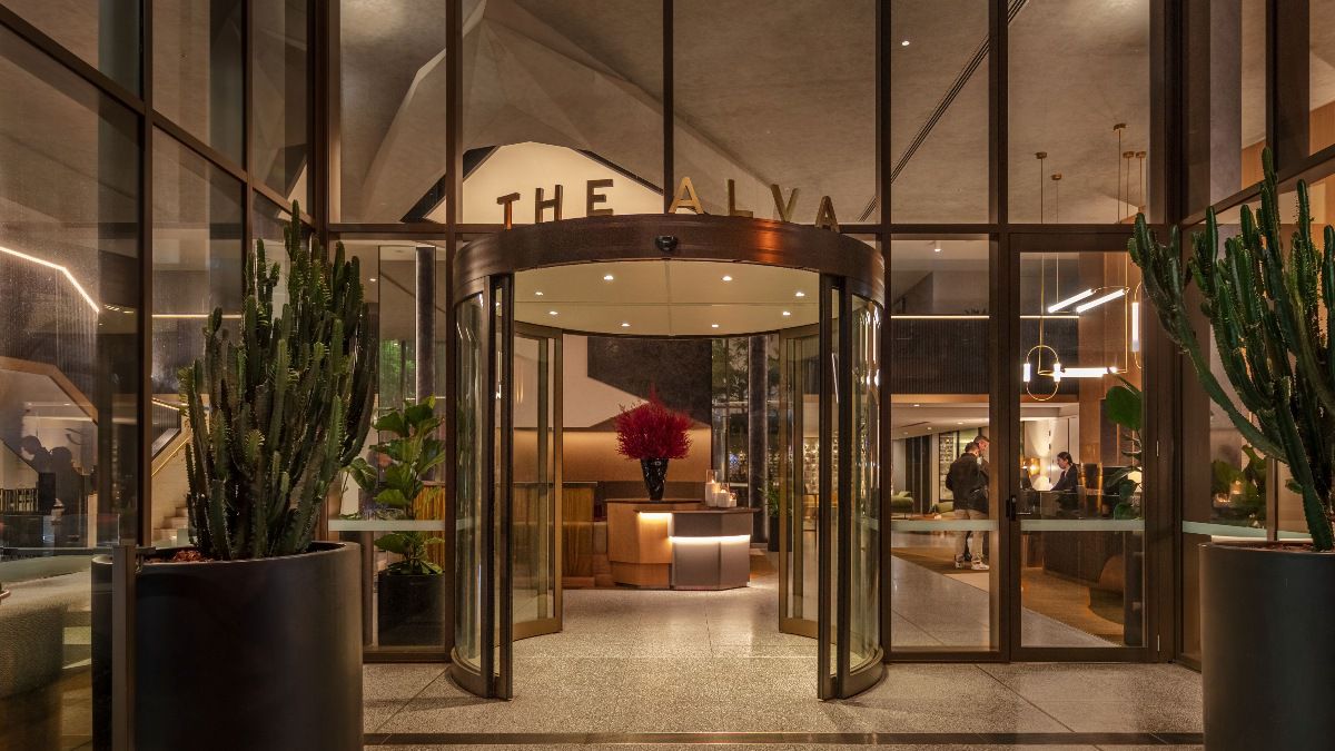 Elegant hotel entrance with glass doors and greenery