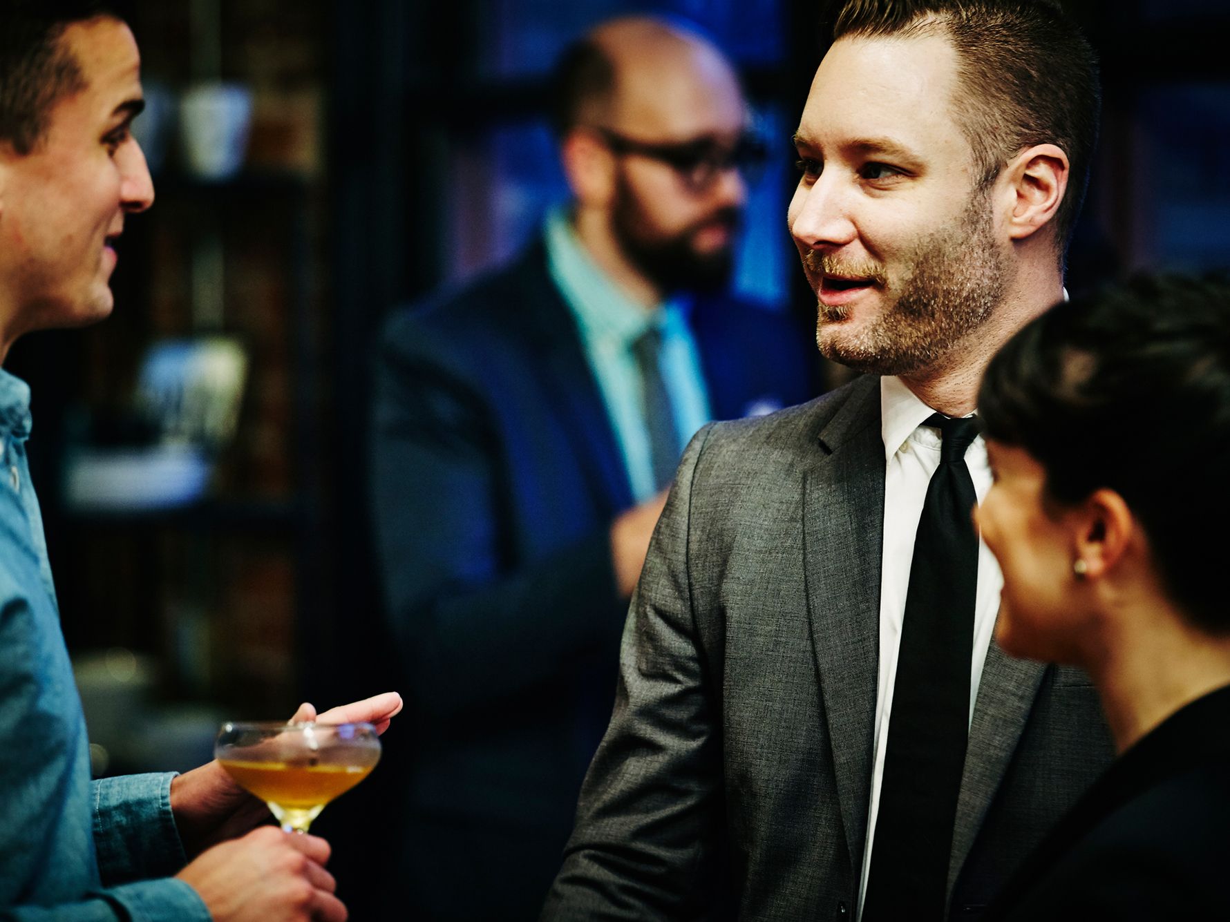 Men having conversation at a party with drinks