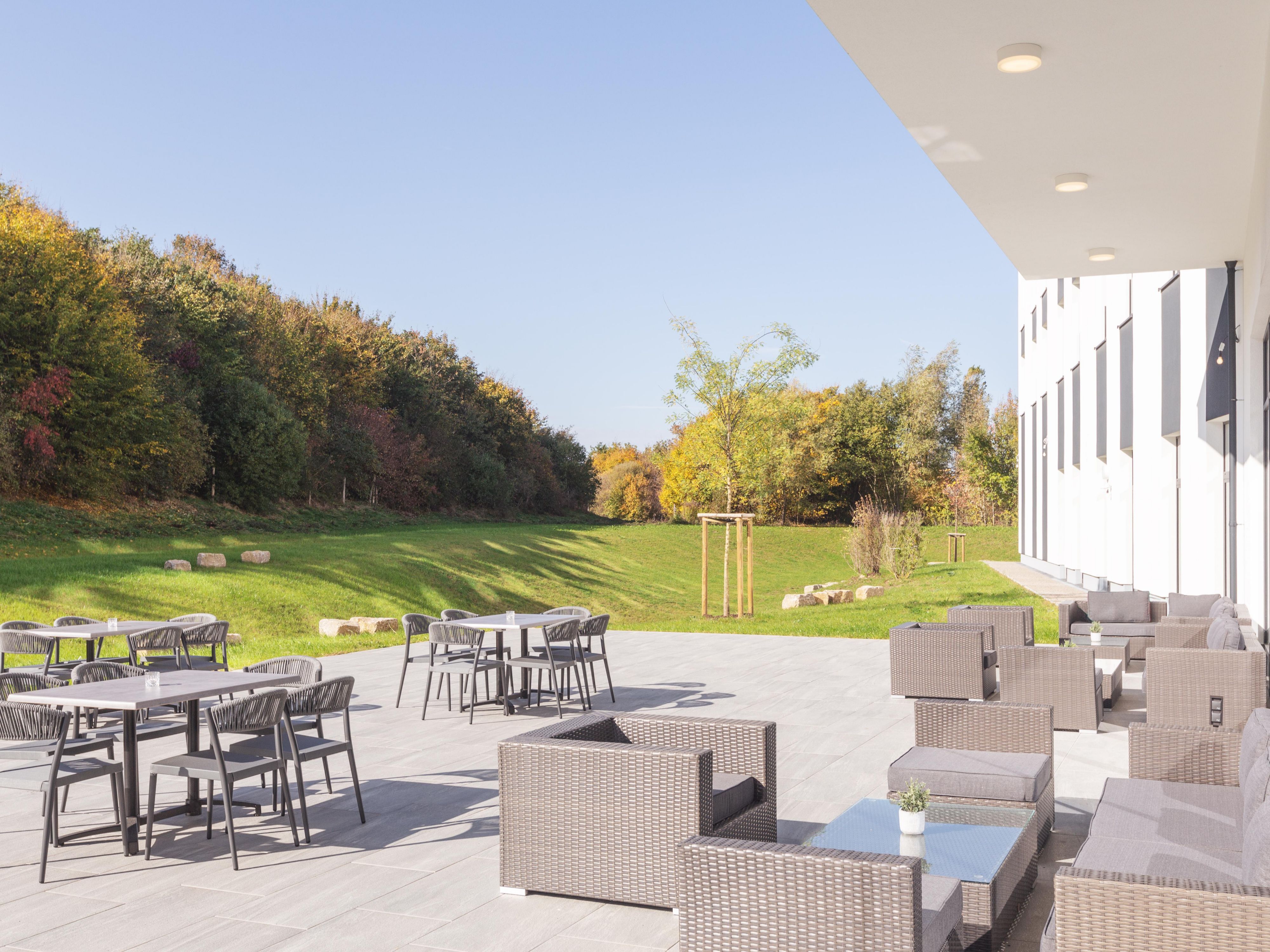 Whether after a long day at work or to get some fresh air in between: our spacious and beautifully landscaped outdoor area with lounge terrace invites you to linger.