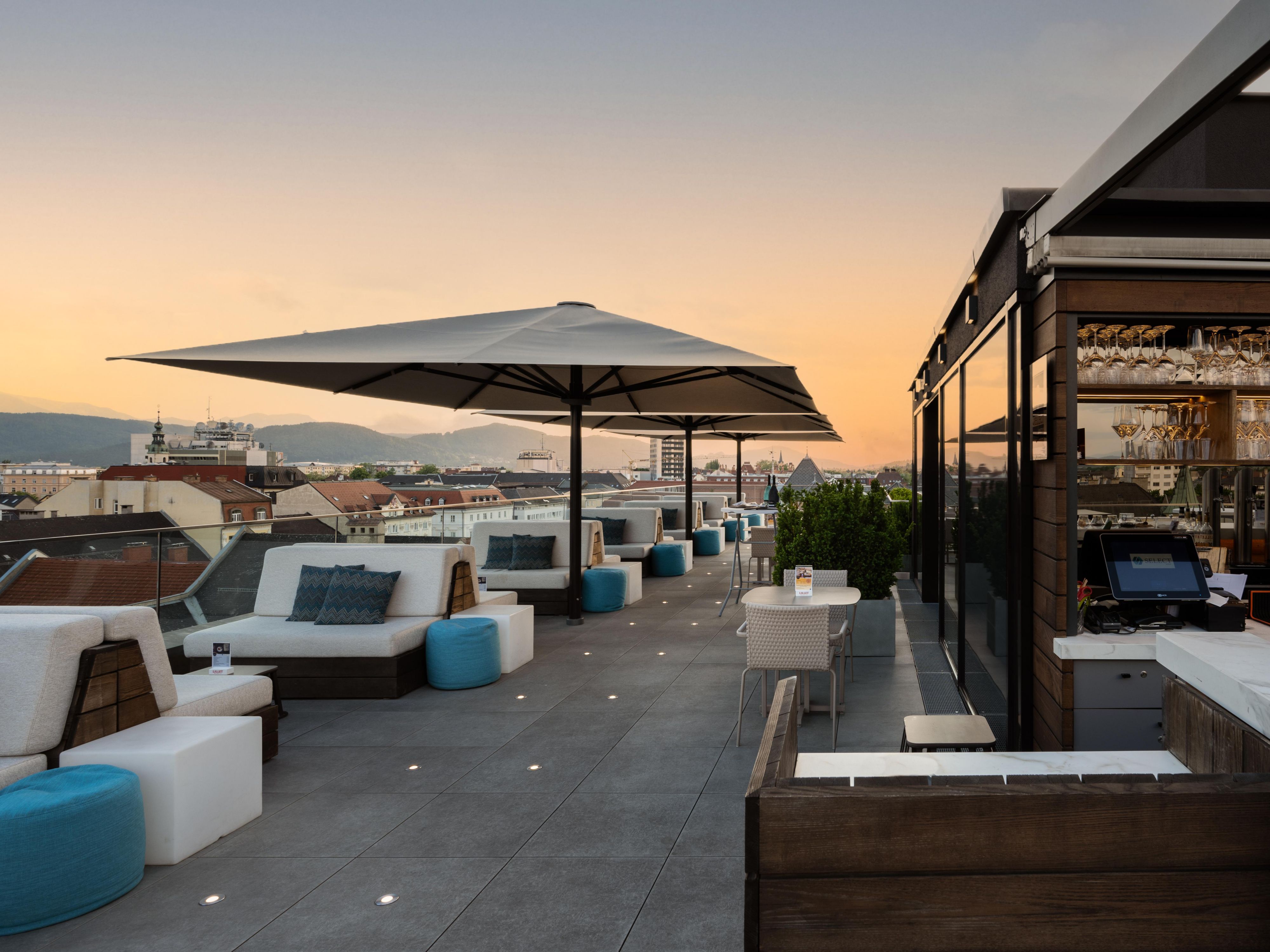 Experience Klagenfurt from a whole new angle at the city’s premier rooftop terrace – Bar 19null7! Unwind above the rooftops with panoramic views of the historic Old Town and distant alpine peaks. Sip on expertly crafted drinks, enjoy a light bite, and soak in unforgettable sunsets in a stylish, relaxed atmosphere