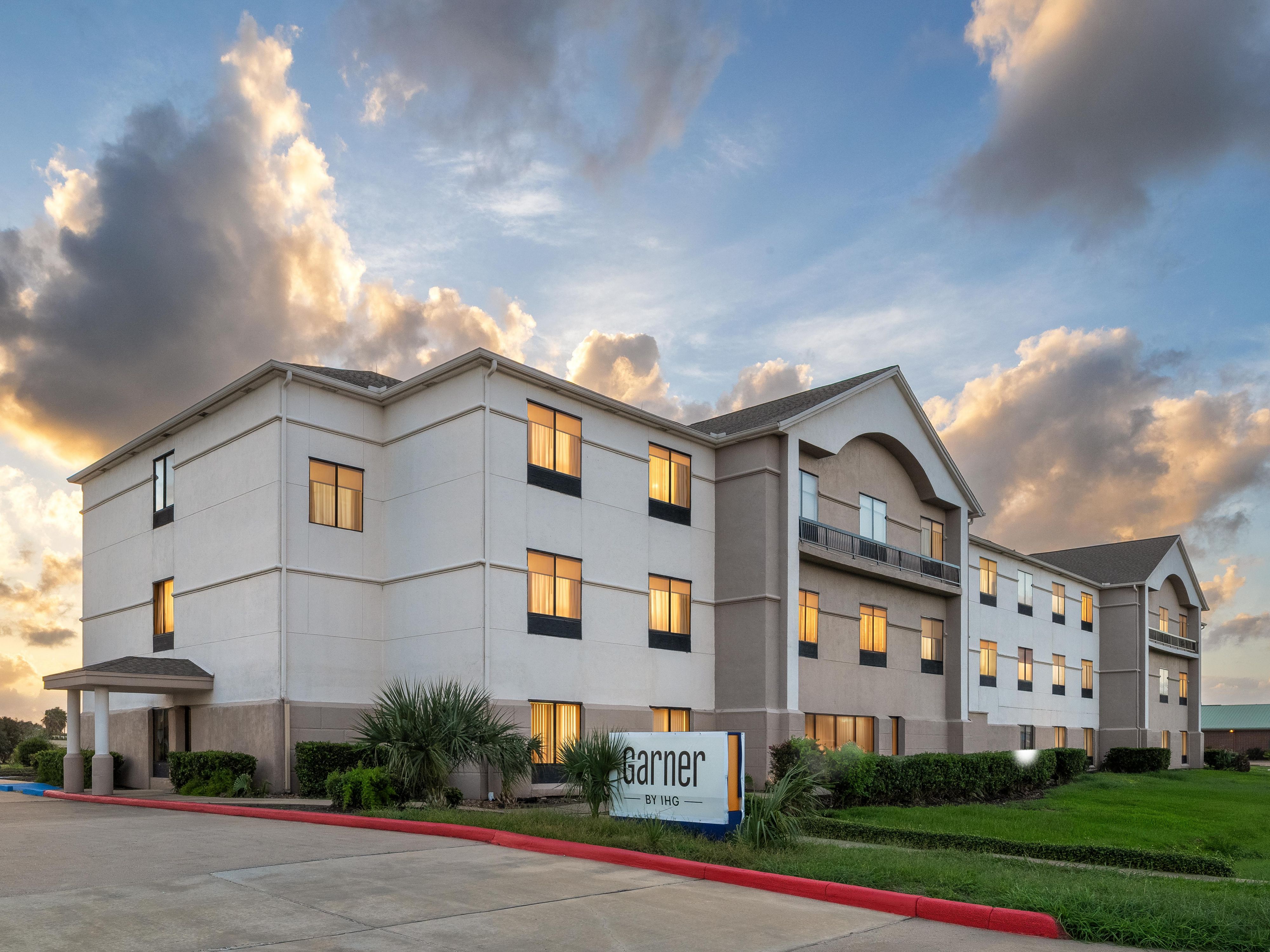 Exterior view of hotel at dusk with signage