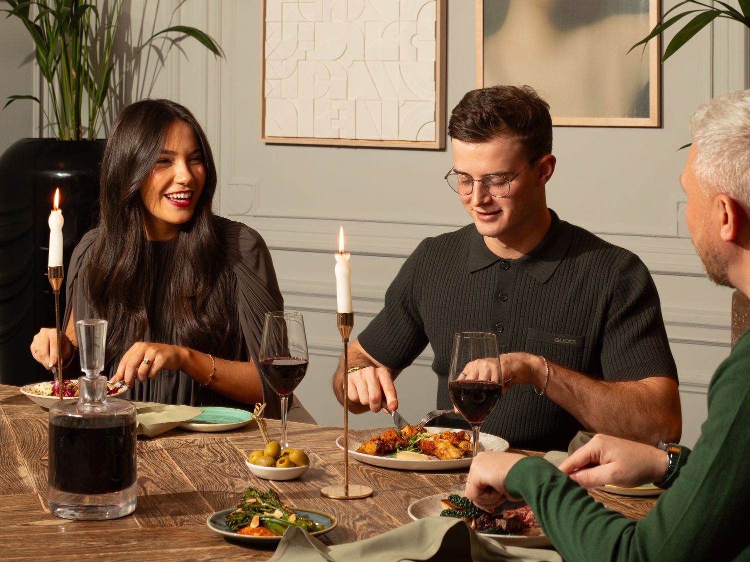 A group of three enjoying wine and a meal