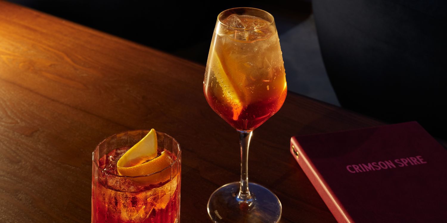 two crimson spire cocktails and a menu