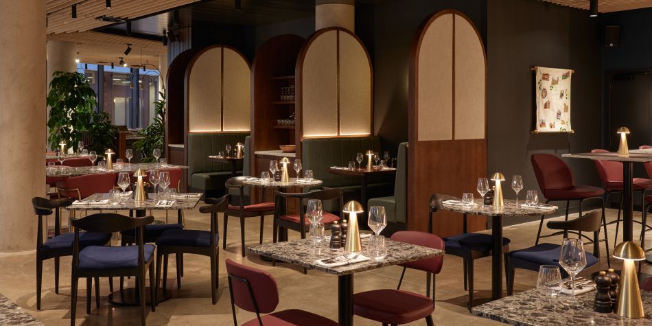 dim lit restaurant with plenty seating a wooden panelled ceiling