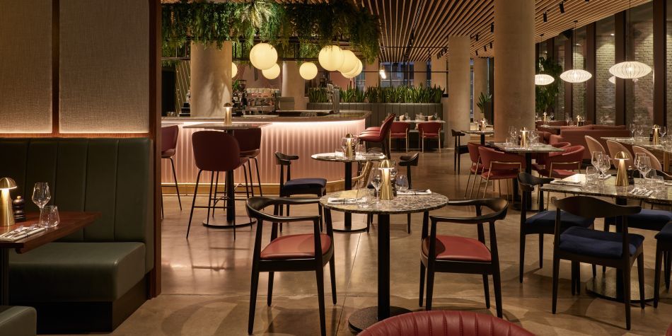 dim lit restaurant with plenty seating and a large pink bar