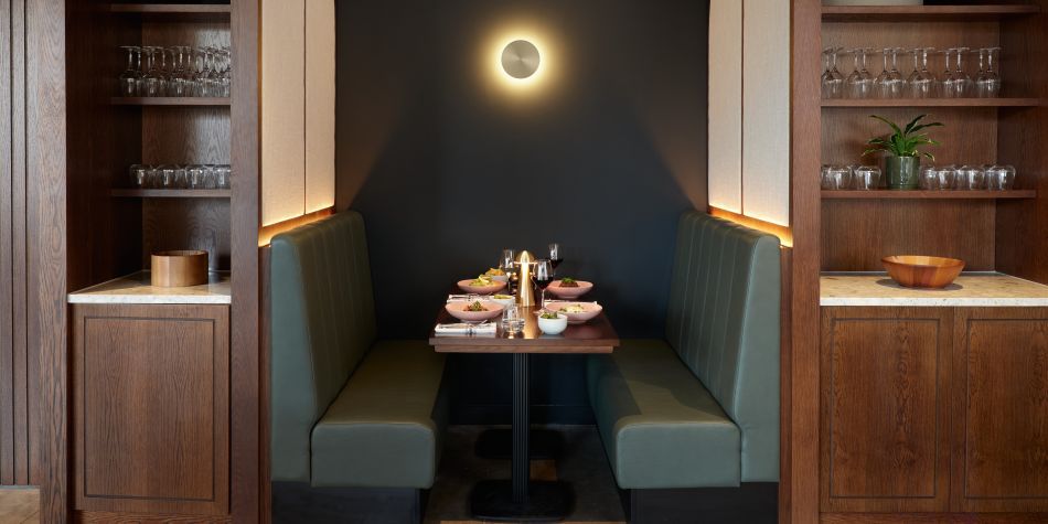 green coloured booth with dim lighting and dishes on the table