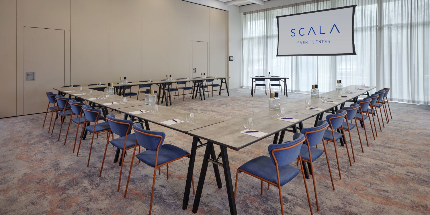 medium meeting room with screen, water, paper and pens