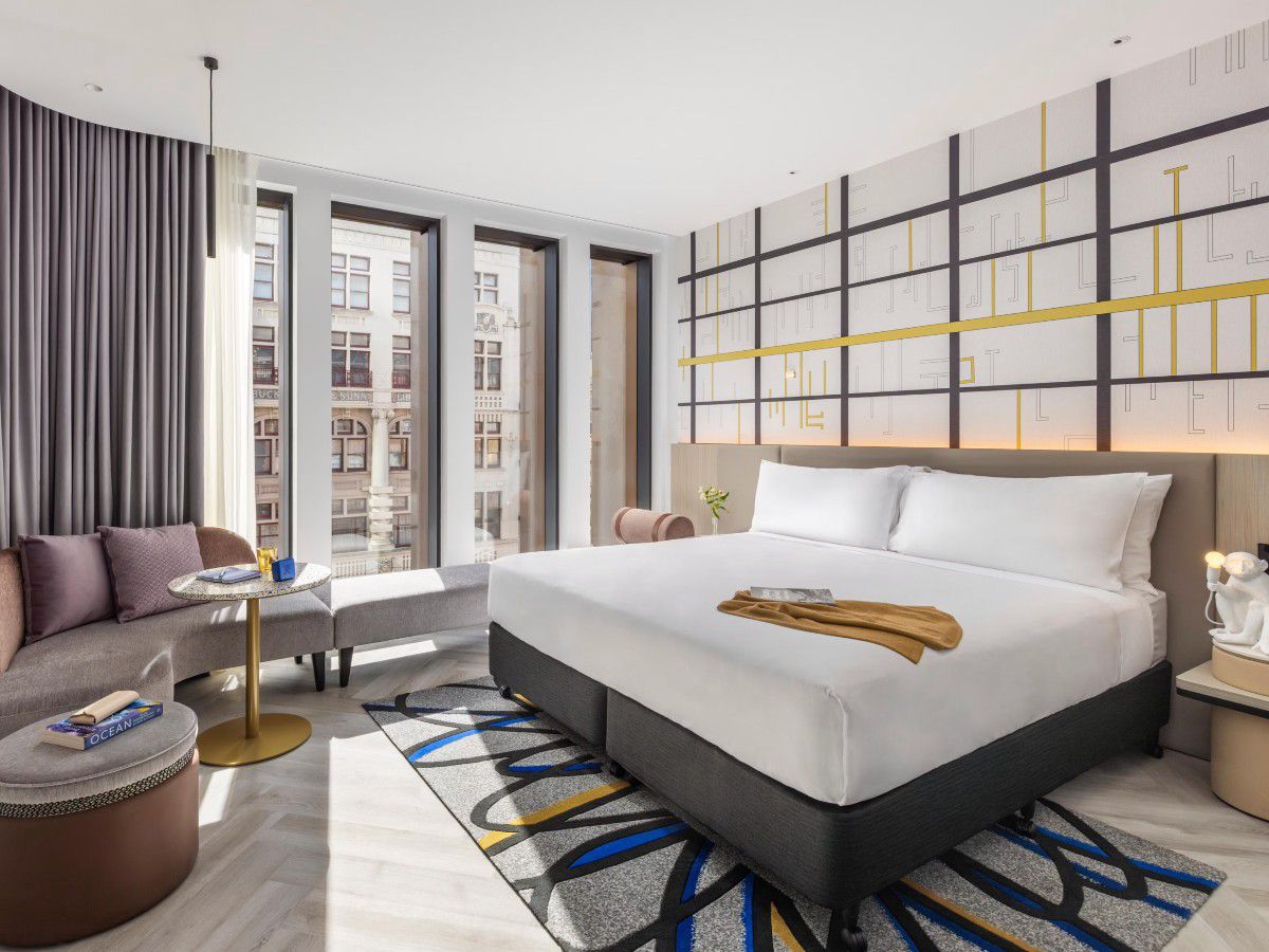 Modern hotel room with king bed and city views.