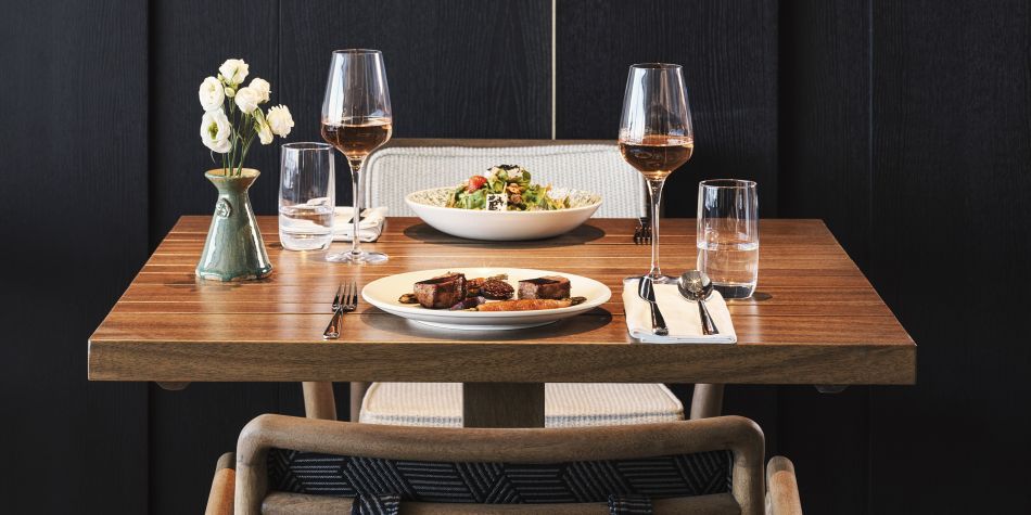 Dining table plated with various dishes and red wine