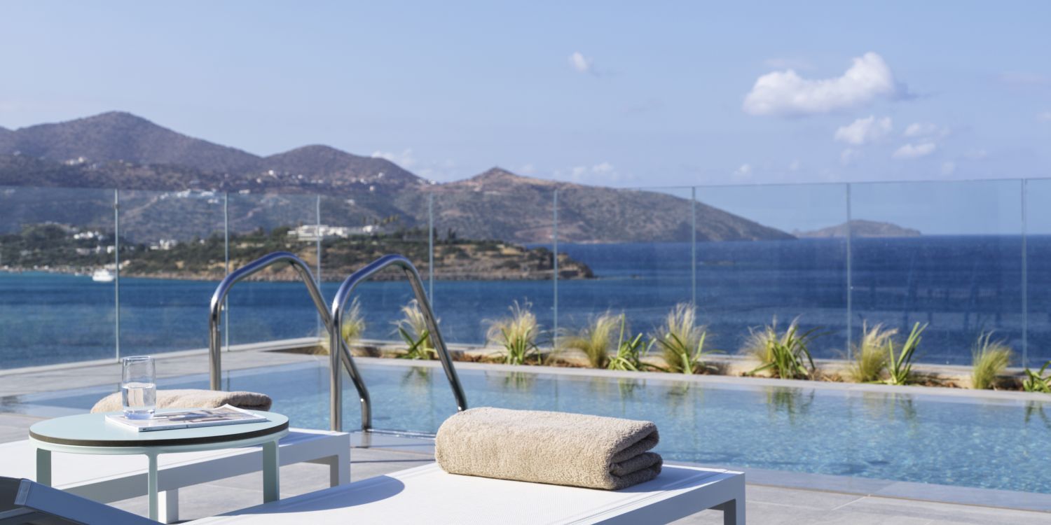 swimming pool overlooking mirabello bay with sunbeds and towels