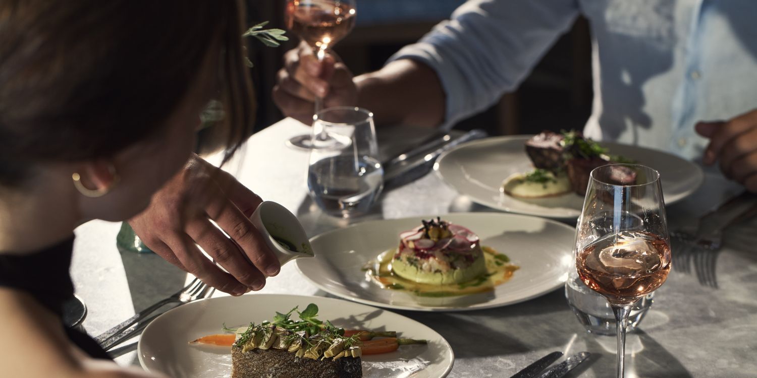 guests dining with various dishes and rose