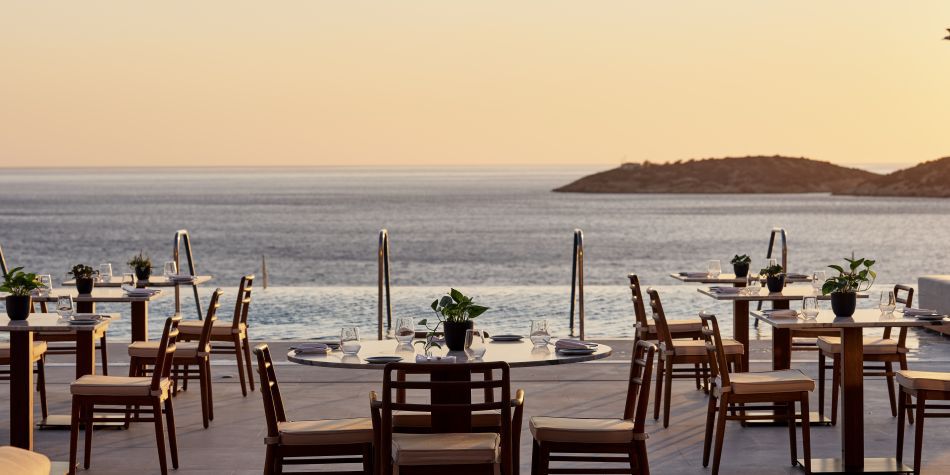 outdoor restaurant dining with panoramic ocean views at sunset