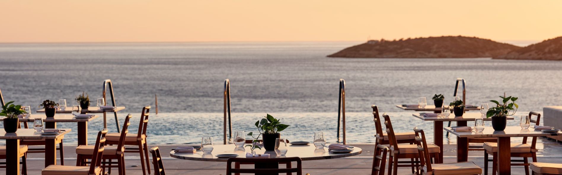 outdoor restaurant dining with panoramic ocean views at sunset