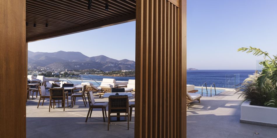 rooftop dining and bar area in daytime with stunning pool and ocean views