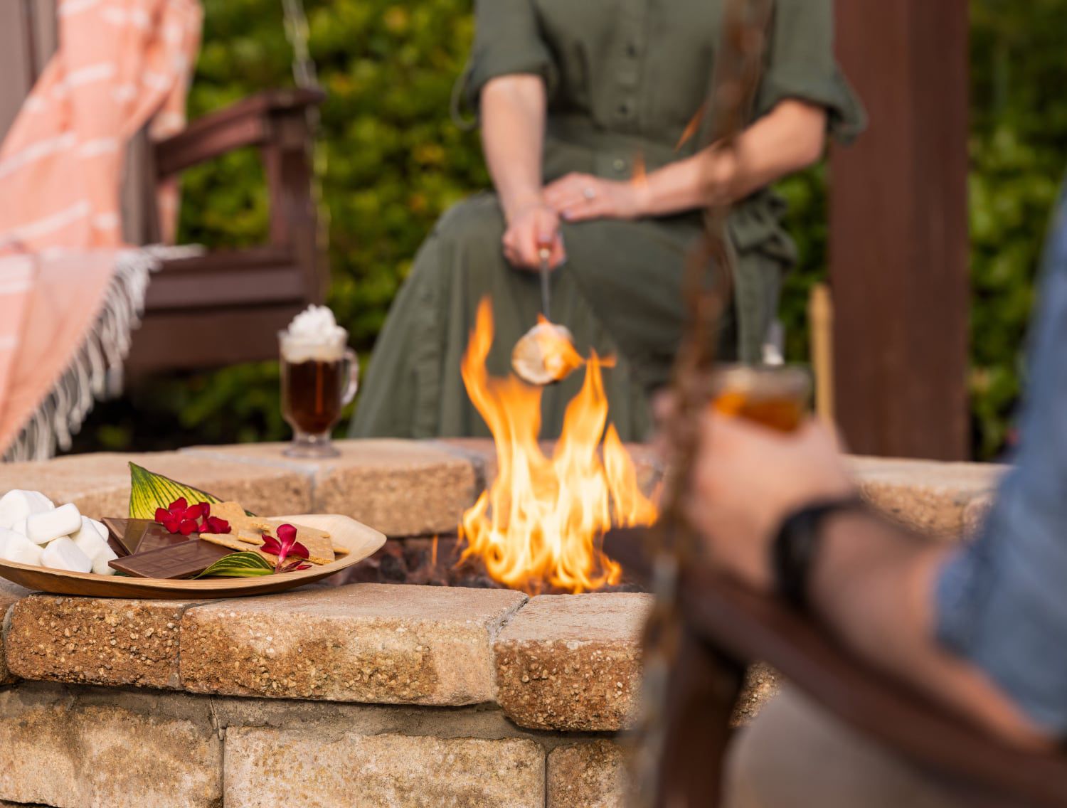 People gathered around a fire pit roasting marshmallows