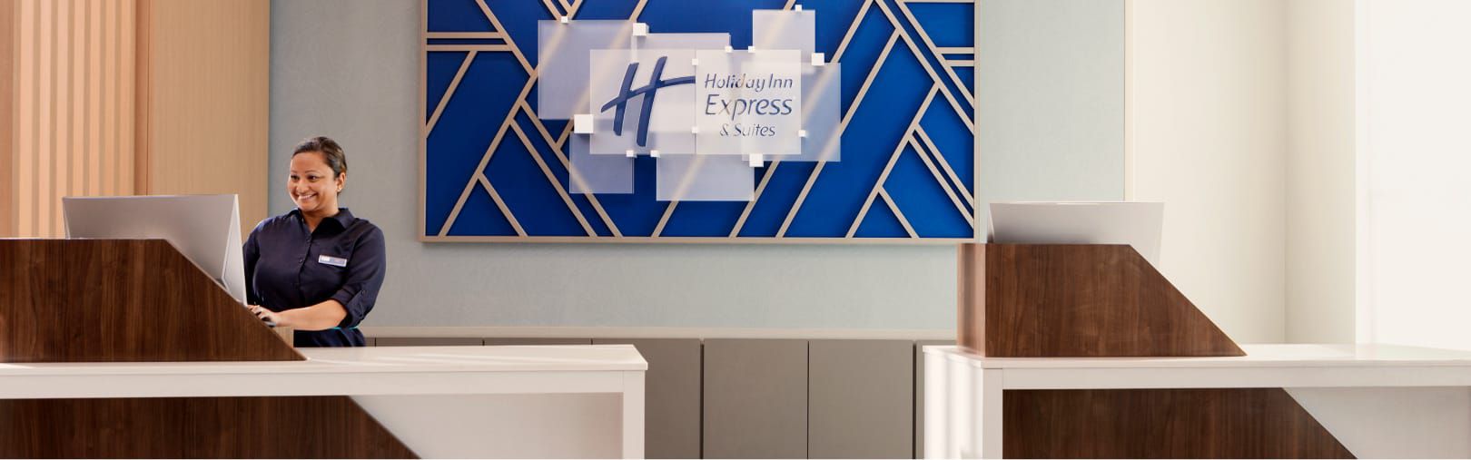 Una empleada de recepción sonríe en un Holiday Inn Express.