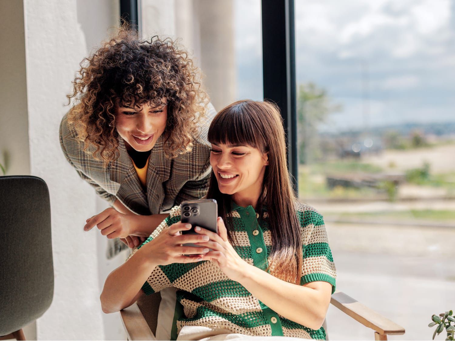 Two women planning an event on a smartphone.